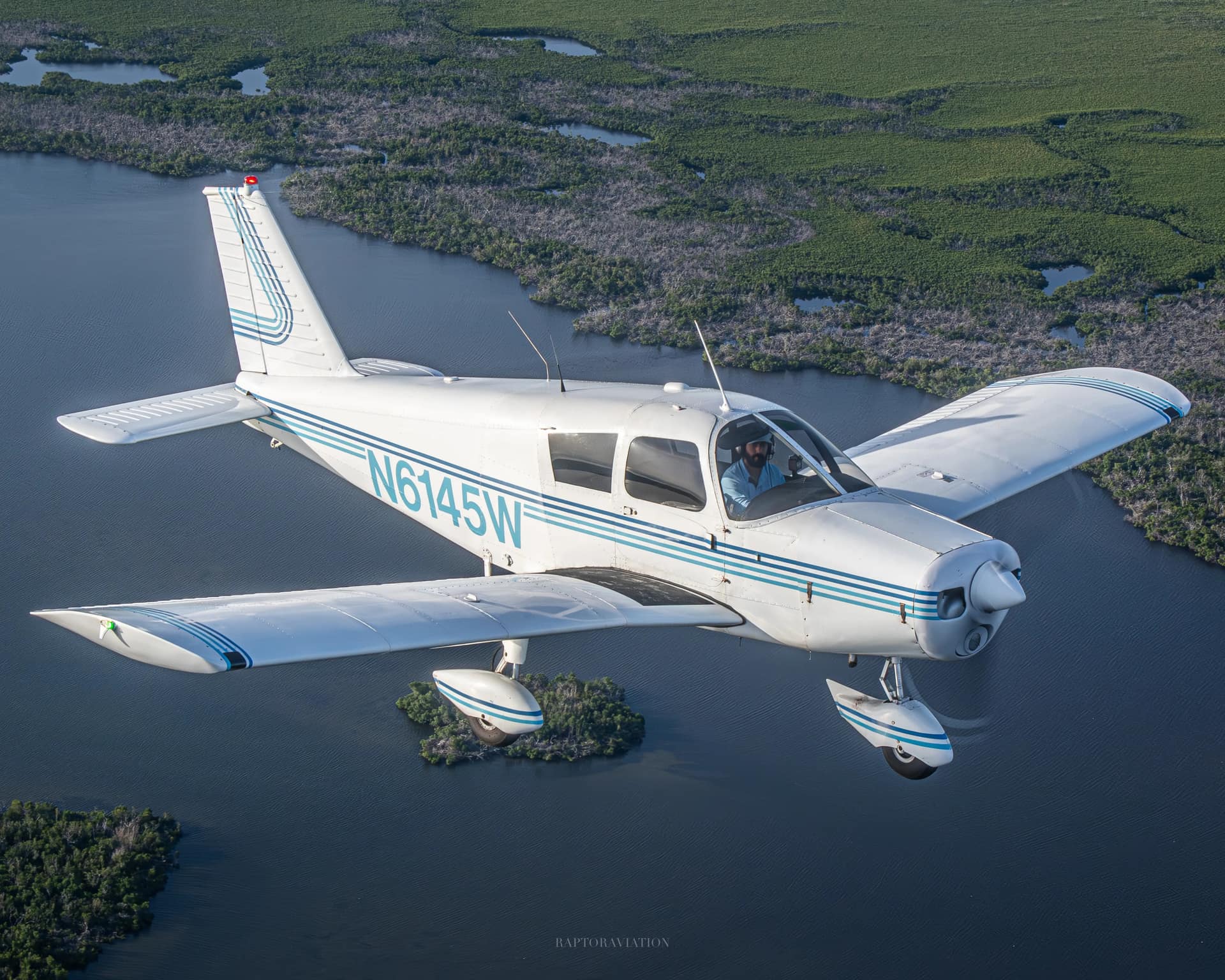 Piper Cherokee 140 N6145W banking over mangrove waterways near Fort Myers